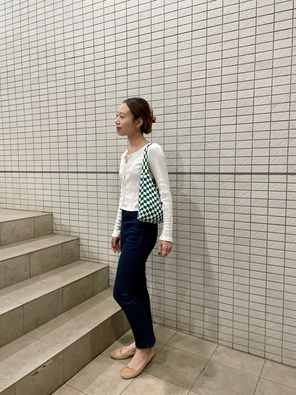 ホワイト系のTシャツ/カットソー、ブルー系のデニムパンツ、グリーン系のトートバッグを着用したレディースの夏コーディネートの2枚目の写真