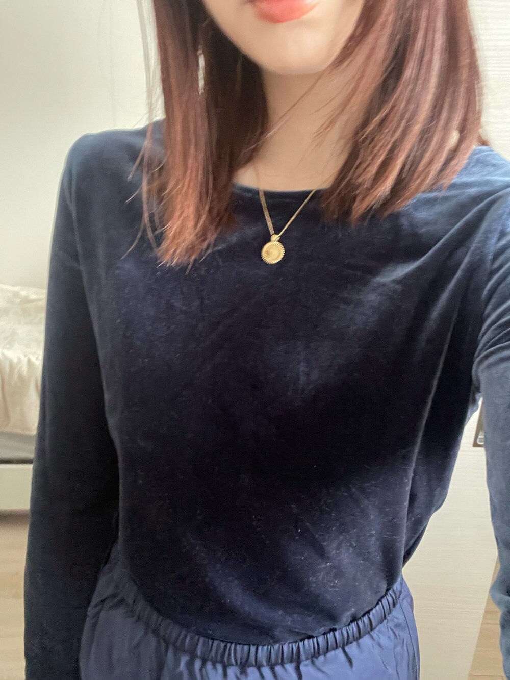 ブルー系のTシャツ/カットソー、ブルー系のスカート、ゴールド系のネックレスを着用したレディースの冬コーディネートの2枚目の写真