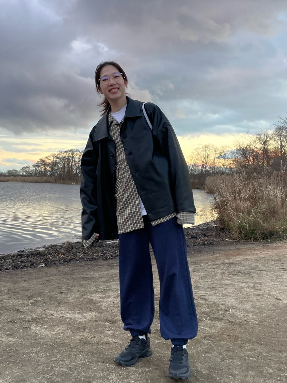 ブラック系のブルゾン、グリーン系のシャツ/ブラウス、ブルー系のスウェットパンツを着用したレディースの冬コーディネートの2枚目の写真