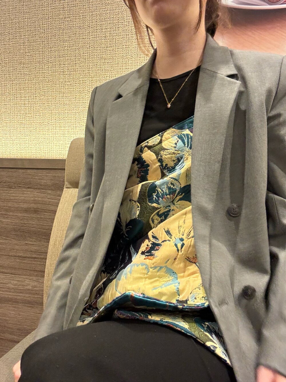 グレー系のテーラードジャケット、ブルー系のスカート、ブラック系のその他パンツを着用したレディースの春コーディネートの2枚目の写真