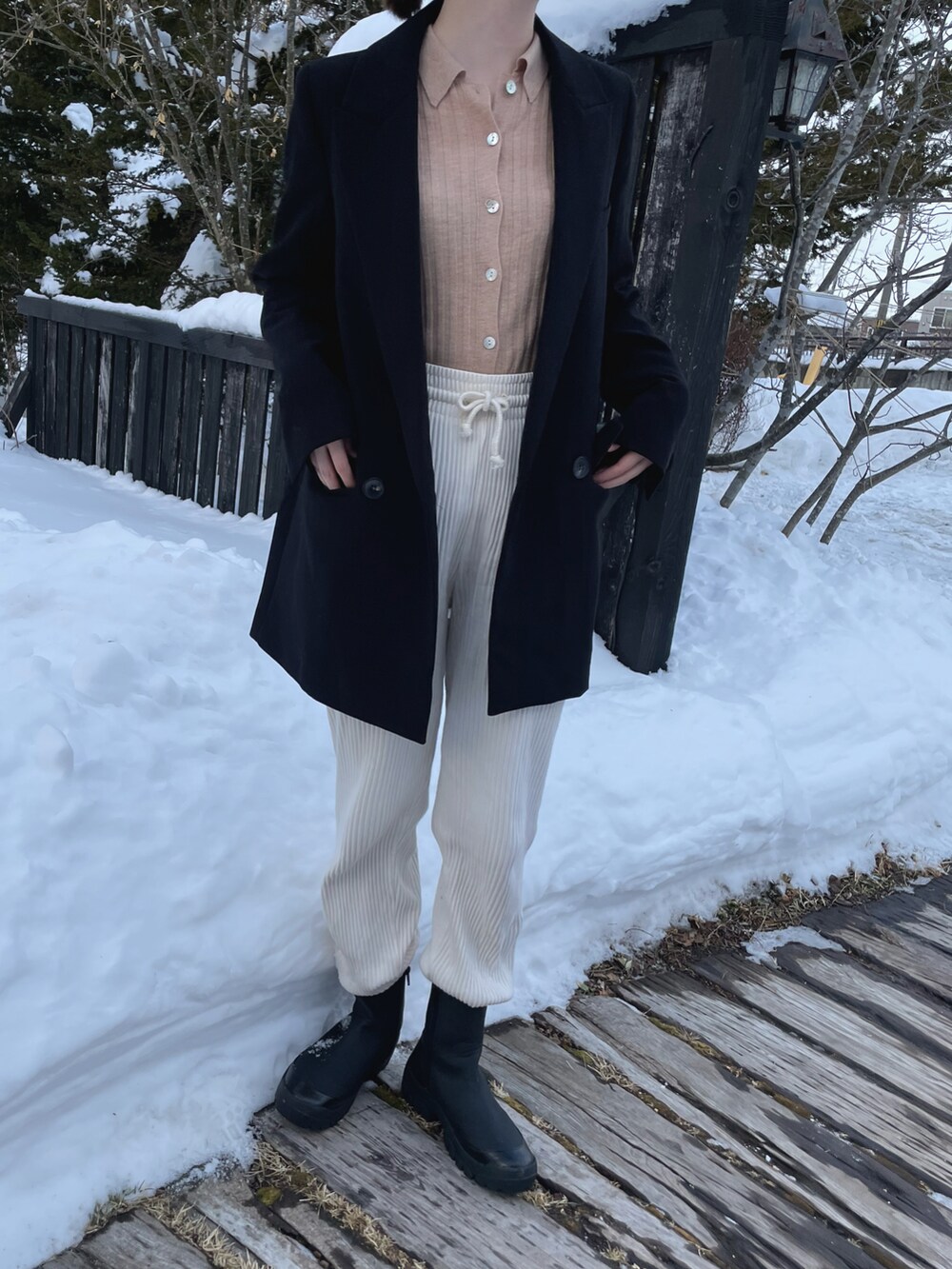 ブラック系のジャケット/アウター、ベージュ系のTシャツ/カットソー、ホワイト系のその他パンツを着用したレディースの冬コーディネートの2枚目の写真