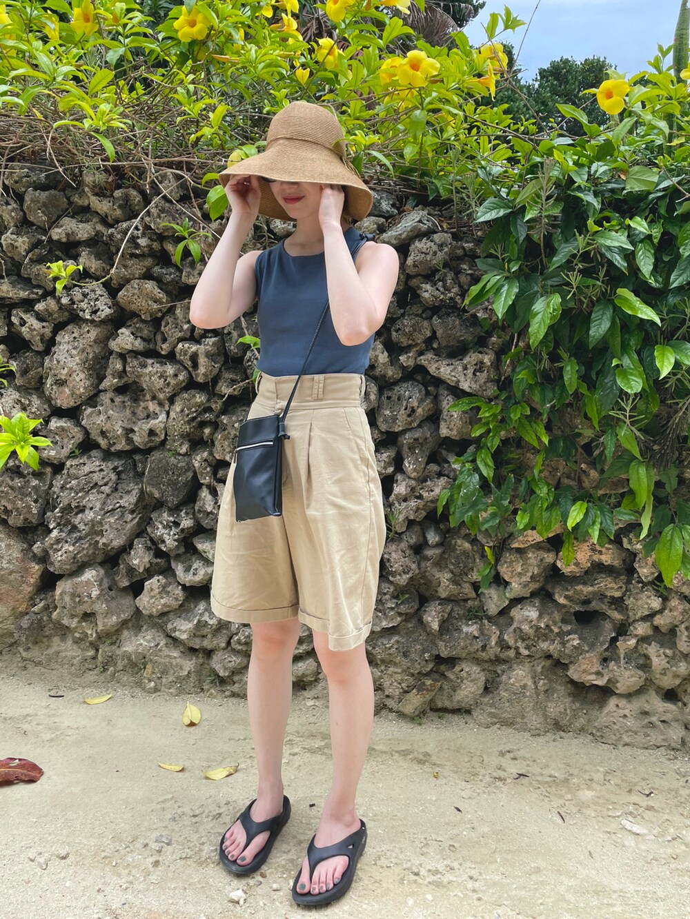 ブルー系のタンクトップ、ベージュ系のパンツ、ホワイト系のニット/セーターを着用したレディースの夏コーディネートの2枚目の写真