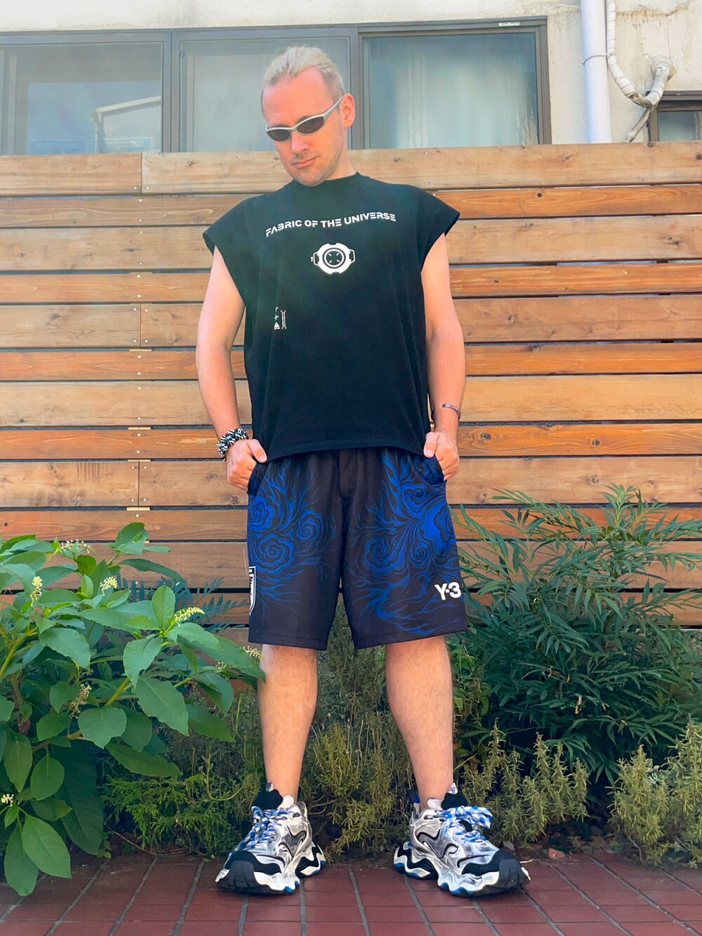 ブラック系のタンクトップ、ブラック系のその他パンツ、ホワイト系のスニーカーを着用したメンズの夏コーディネートの2枚目の写真