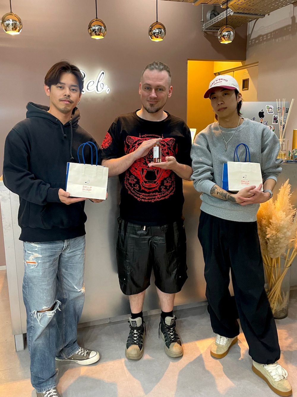 ブラック系のトップス、ブラック系のカーゴパンツ、ブラック系のスニーカーを着用したメンズの春コーディネートの2枚目の写真