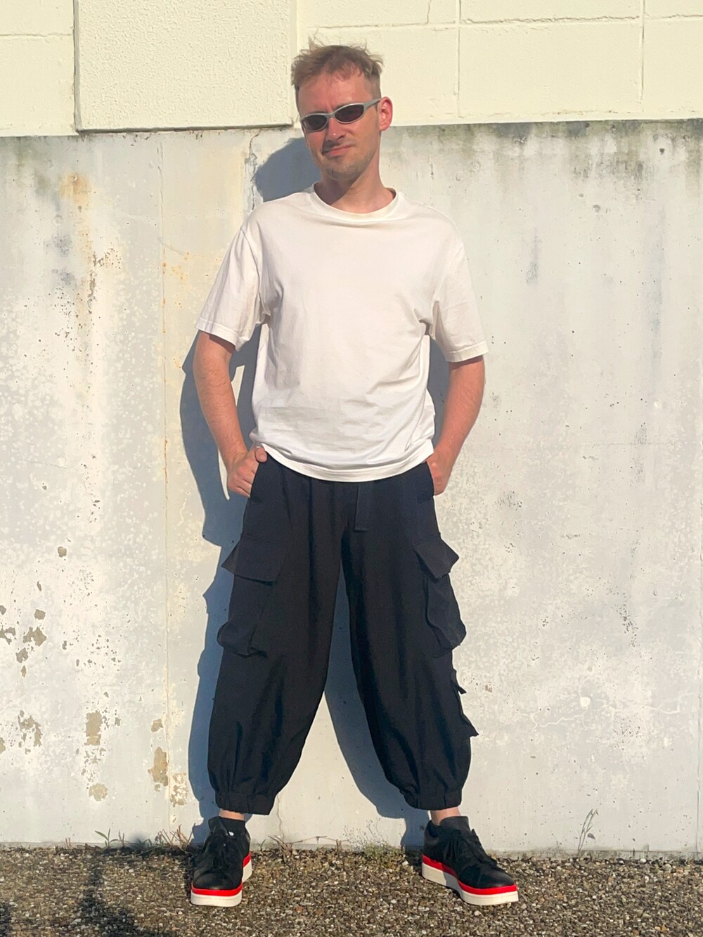 ホワイト系のTシャツ/カットソー、ブラック系のその他パンツ、ブラック系のスニーカーを着用したメンズの夏コーディネートの2枚目の写真