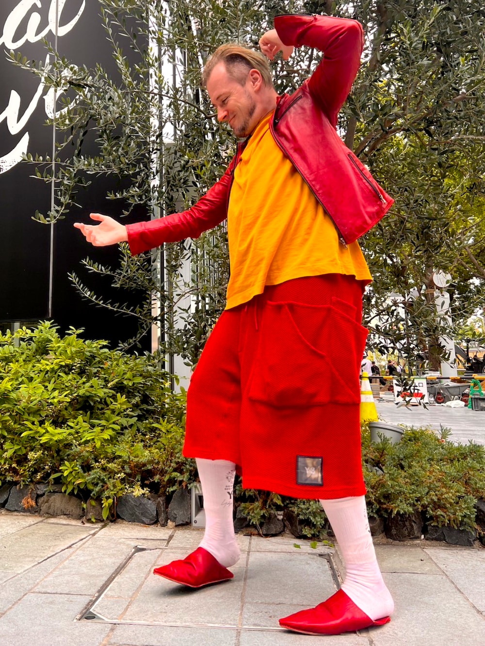 イエロー系のTシャツ/カットソー、レッド系のライダースジャケット、レッド系のその他パンツを着用したメンズの秋コーディネートの5枚目の写真