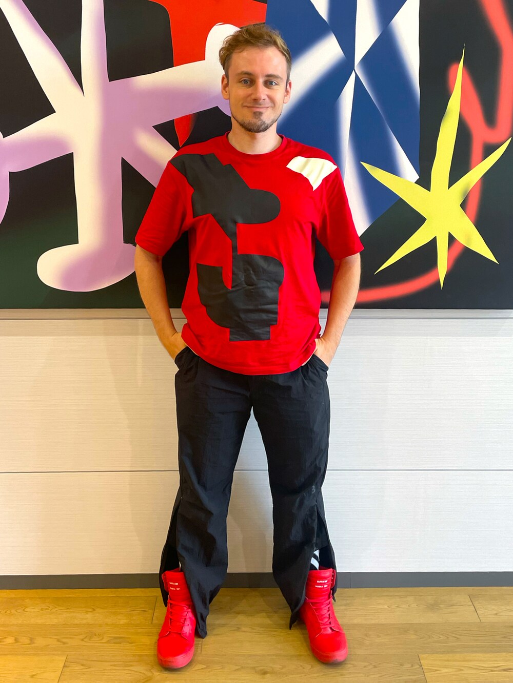 レッド系のTシャツ/カットソー、ブラック系のその他パンツ、レッド系のスニーカーを着用したメンズの夏コーディネートの2枚目の写真