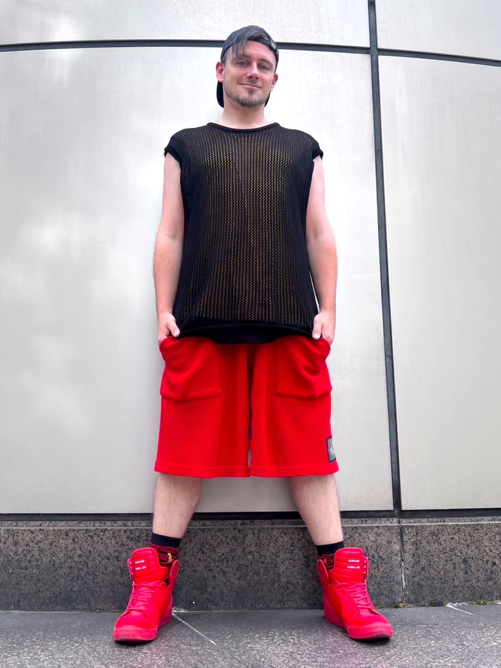 イエロー系のTシャツ/カットソー、ブラック系のベスト、レッド系のその他パンツを着用したメンズの秋コーディネートの2枚目の写真