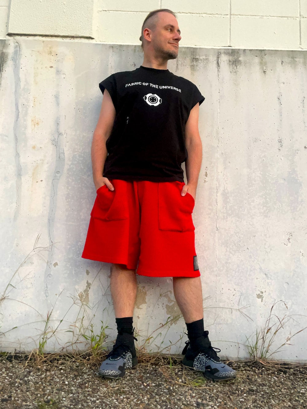 グレー系のスニーカー、レッド系のその他パンツ、ブラック系のタンクトップを着用したメンズの秋コーディネートの2枚目の写真