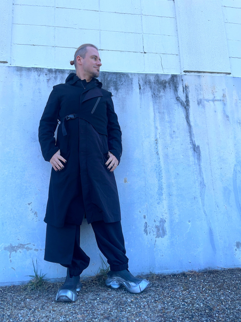 ブラック系のその他アウター、ブラック系のカーゴパンツ、グレー系のスニーカーを着用したメンズの春コーディネートの2枚目の写真