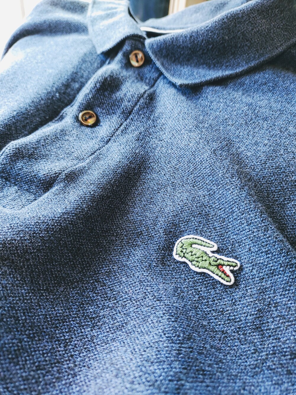 ブルー系のポロシャツを着用したメンズの春コーディネートの3枚目の写真