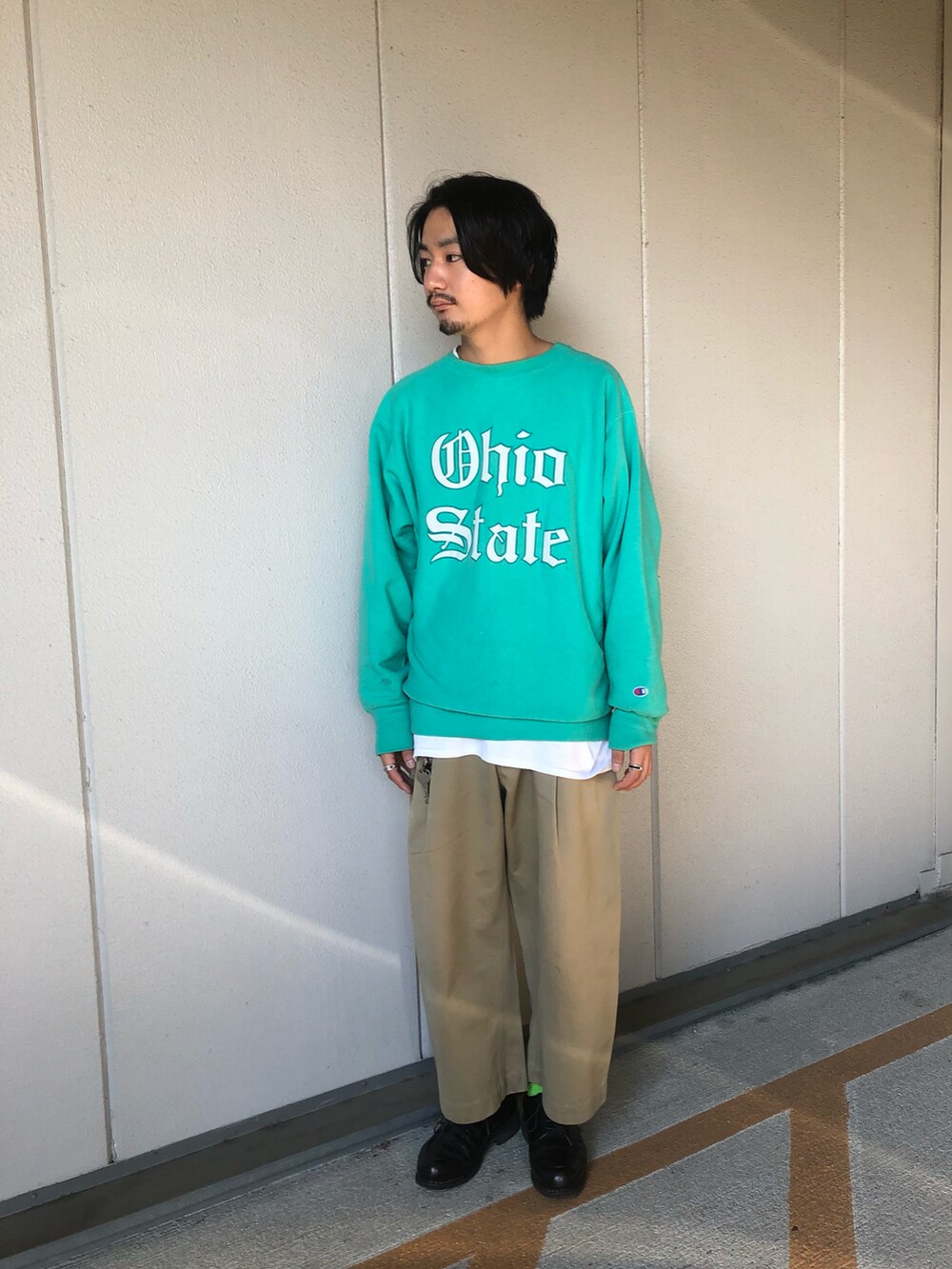 グリーン系のミリタリージャケット、グリーン系のスウェット、ベージュ系のチノパンツを着用したメンズの秋コーディネートの2枚目の写真