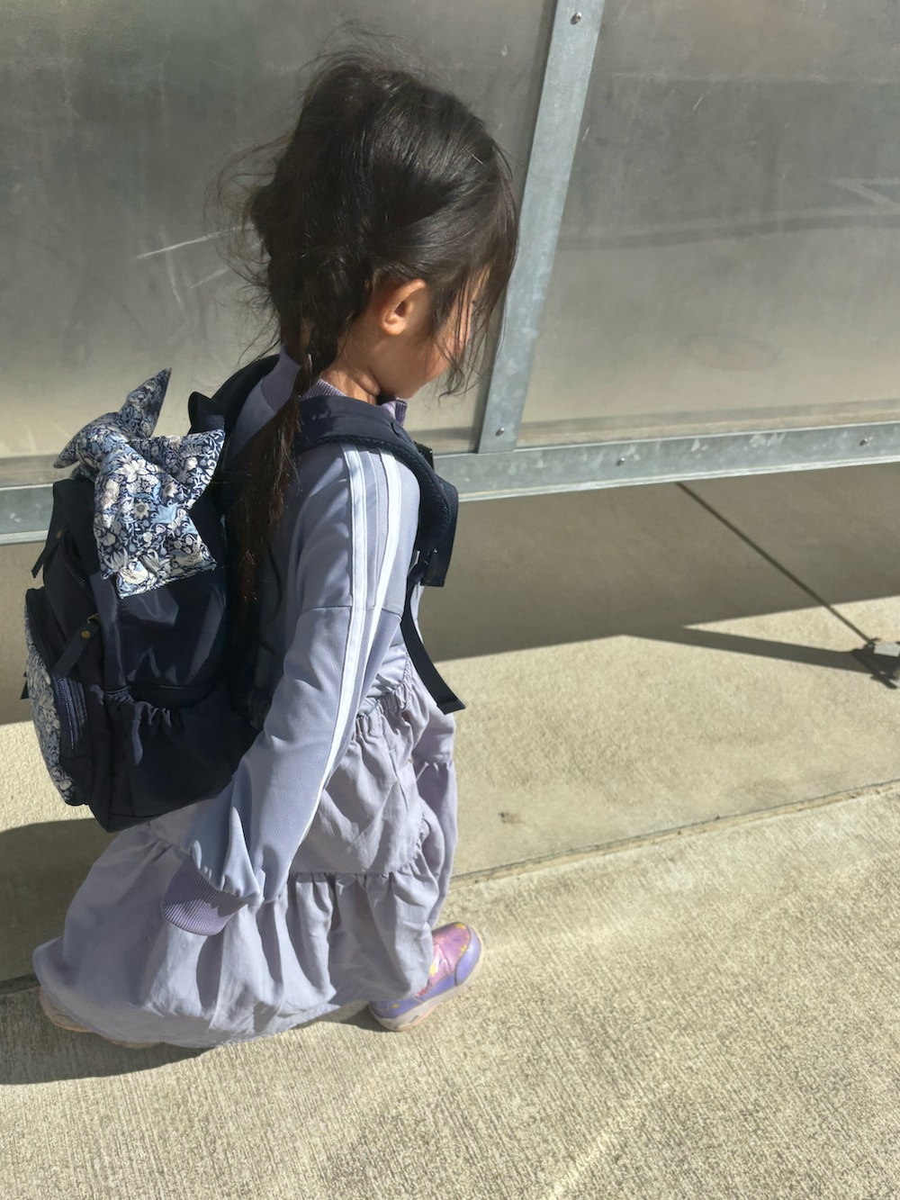 パープル系のワンピース、ブルー系のバックパック/リュックを着用したキッズの冬コーディネートの2枚目の写真