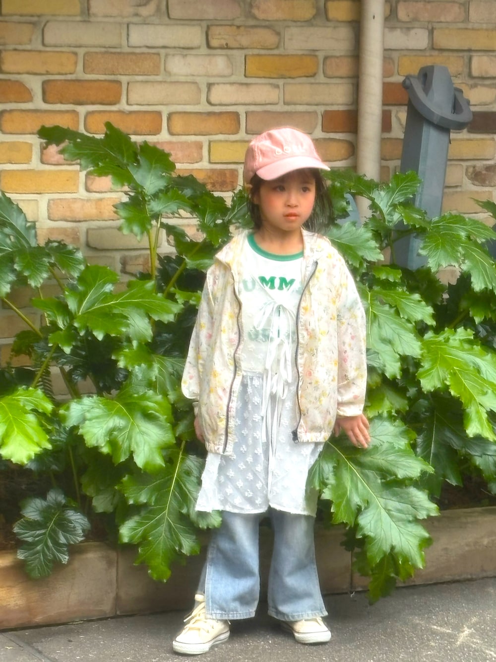 ベージュ系のスニーカー、イエロー系のナイロンジャケット、ホワイト系のTシャツ/カットソーを着用したキッズの春コーディネートの4枚目の写真