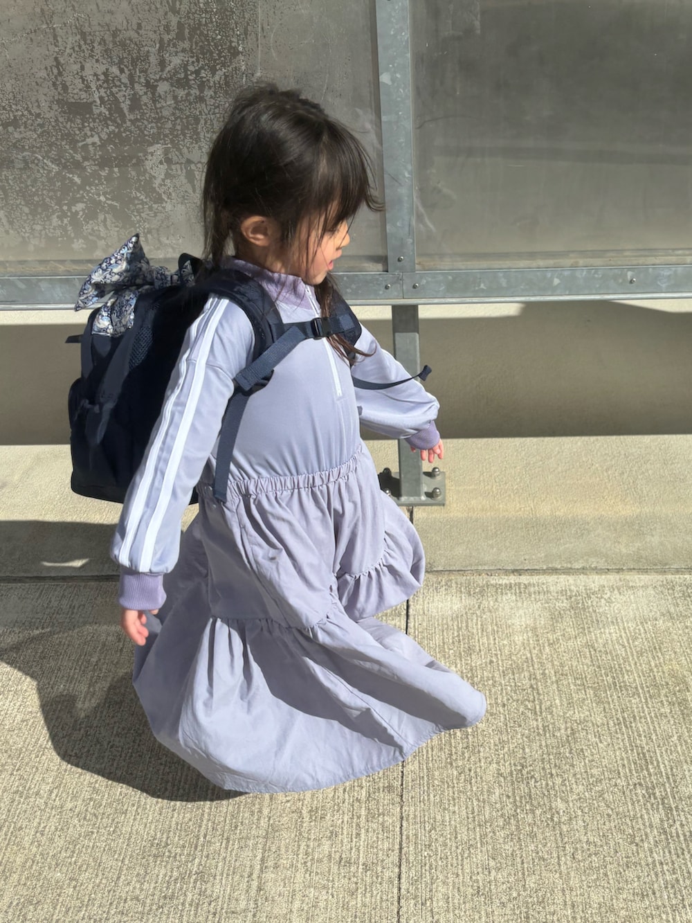 パープル系のワンピース、ブルー系のバックパック/リュックを着用したキッズの冬コーディネートの3枚目の写真