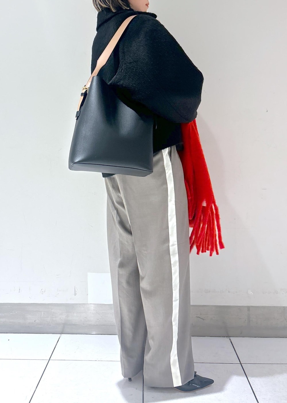 ブラック系のパンプス、ブラック系のその他アウター、グレー系のその他パンツを着用したレディースの冬コーディネートの5枚目の写真