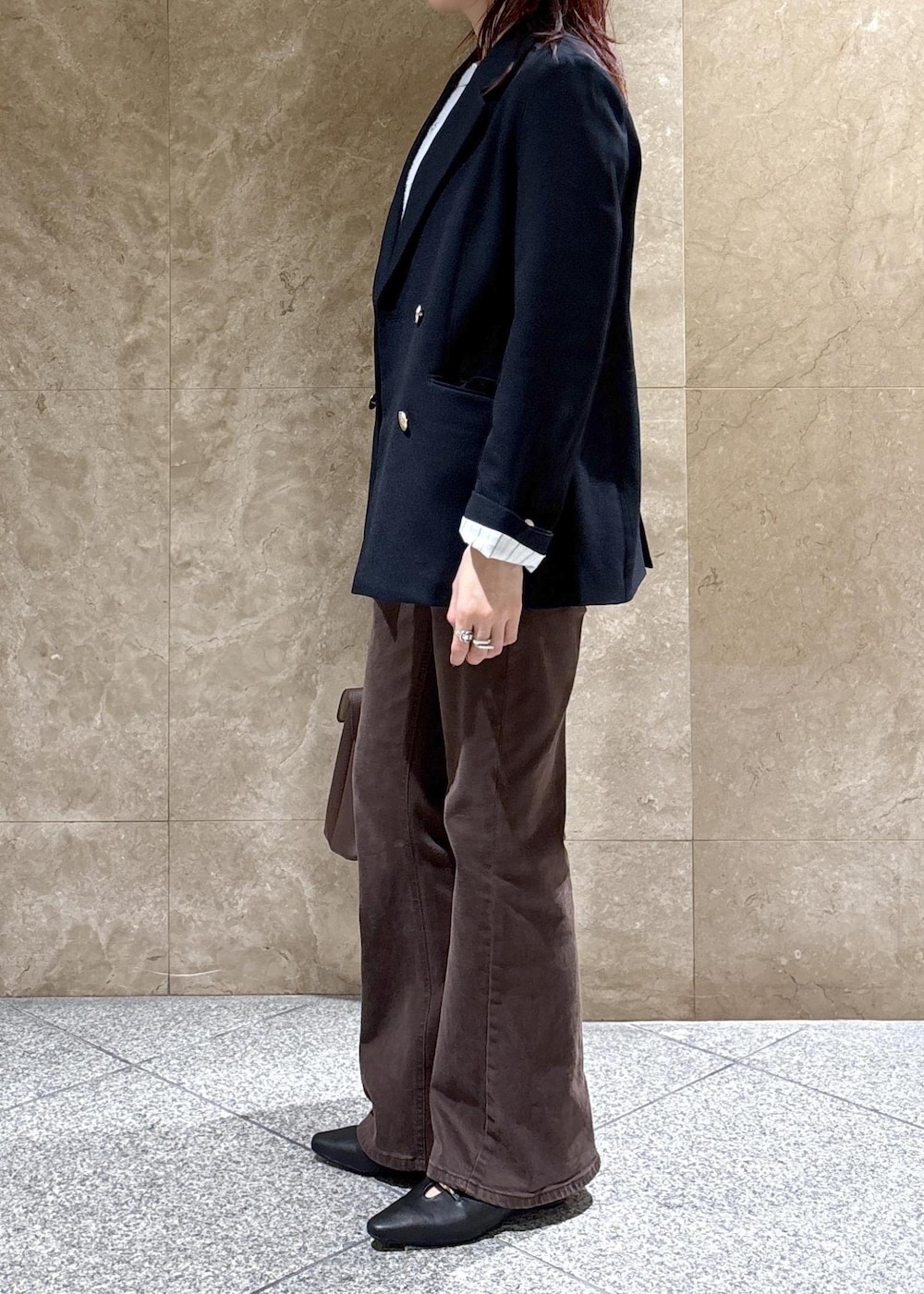 ブラウン系のデニムパンツ、ブラック系のパンプス、ブルー系のニット/セーターを着用したレディースの秋コーディネートの3枚目の写真