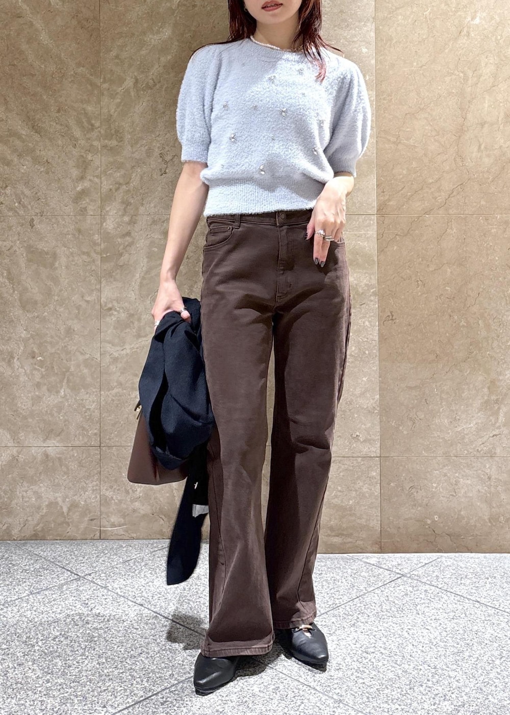 ブラウン系のデニムパンツ、ブラック系のパンプス、ブルー系のニット/セーターを着用したレディースの秋コーディネートの9枚目の写真