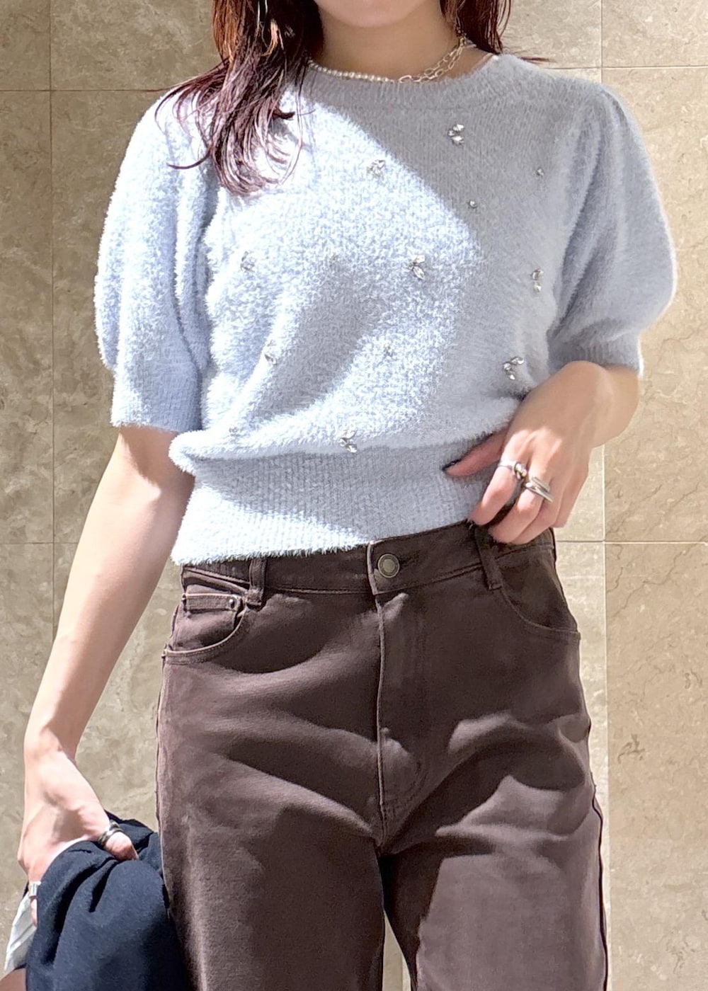 ブラウン系のデニムパンツ、ブラック系のパンプス、ブルー系のニット/セーターを着用したレディースの秋コーディネートの10枚目の写真