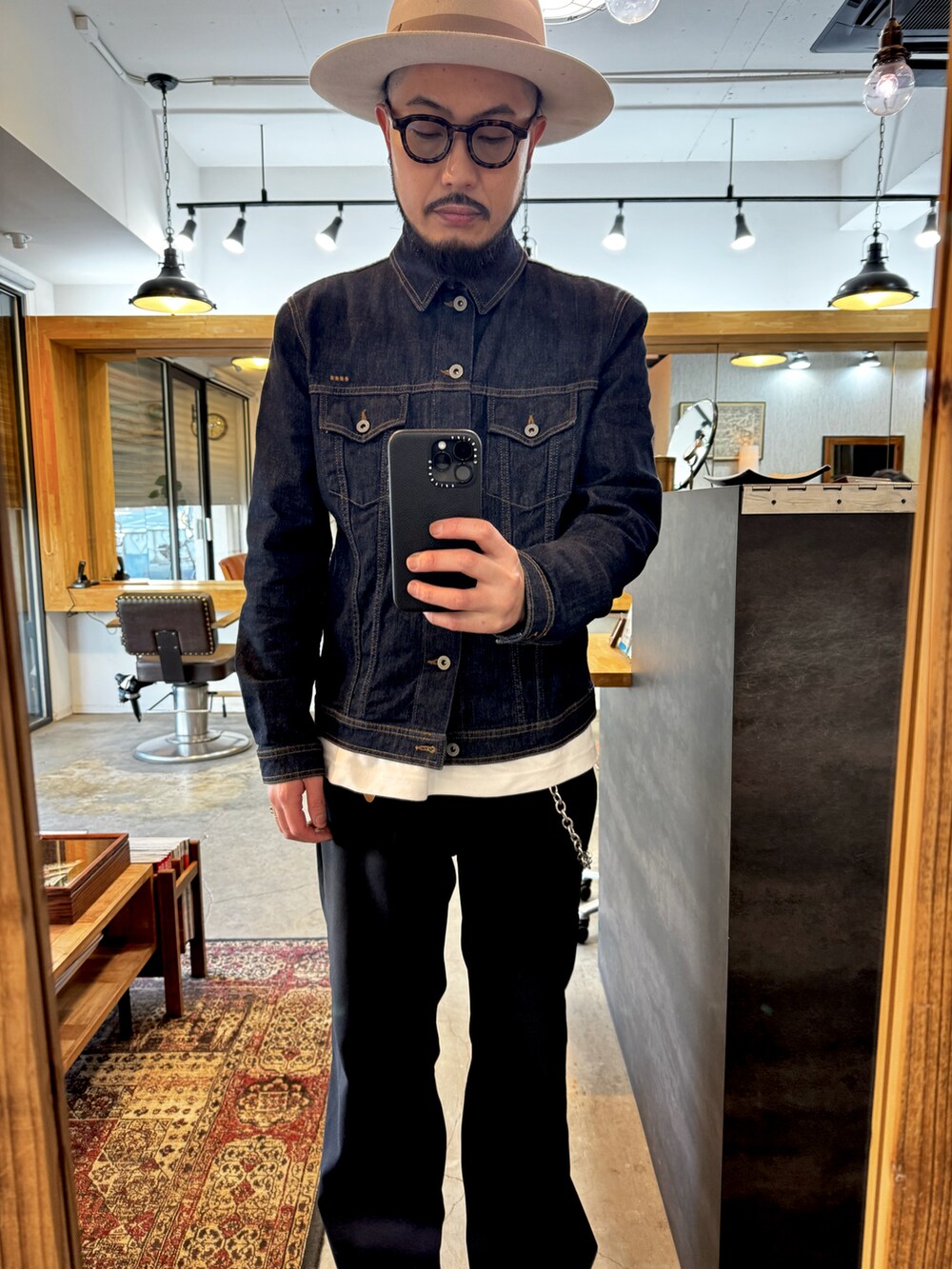 ブラック系のブーツ、ブラック系のスラックス、ブルー系のデニムジャケットを着用したメンズの冬コーディネートの2枚目の写真