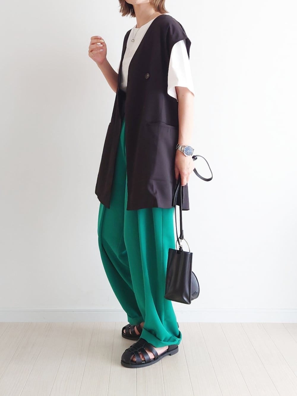 ホワイト系のTシャツ/カットソー、グリーン系のその他パンツ、ブラック系のベストを着用したレディースの春コーディネートの2枚目の写真