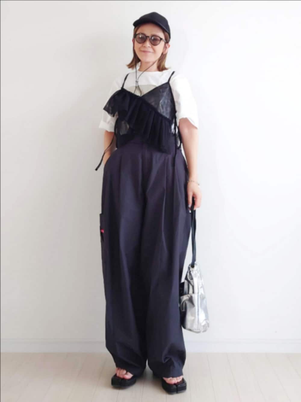 ブラック系のカーゴパンツ、ブラック系のキャミソール、ホワイト系のTシャツ/カットソーを着用したレディースの春コーディネートの5枚目の写真