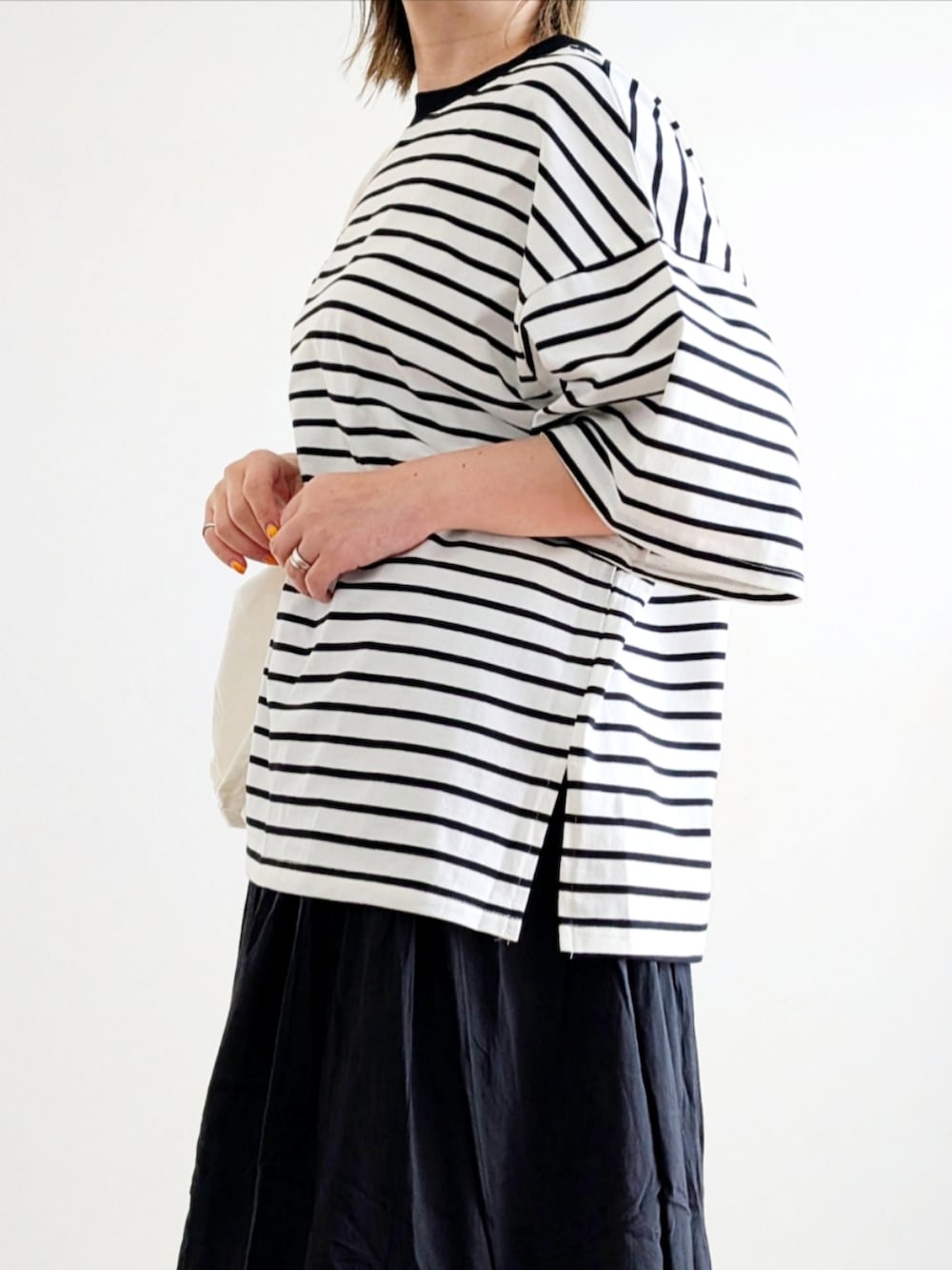 ブラック系のTシャツ/カットソー、ブラック系のスカート、ブラック系のスニーカーを着用したレディースの春コーディネートの5枚目の写真