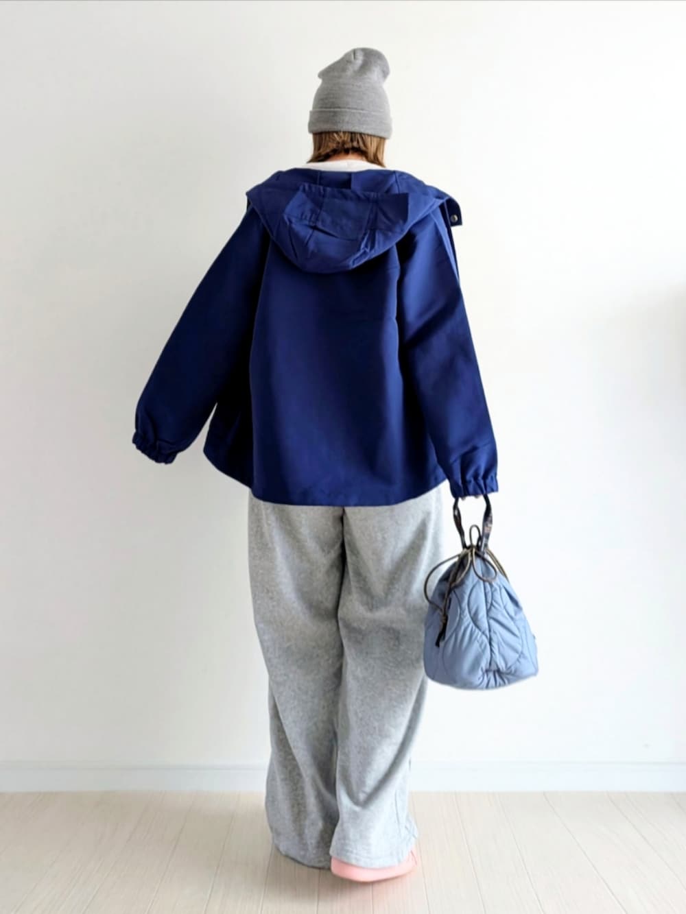 グレー系のスウェットパンツ、ピンク系のスニーカー、ブルー系のマウンテンパーカーを着用したレディースの冬コーディネートの3枚目の写真