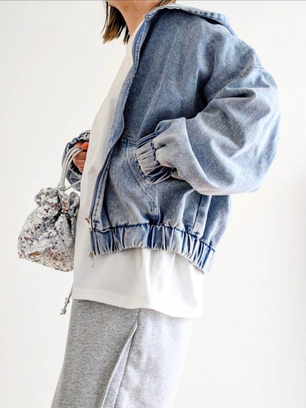 ブルー系のデニムジャケット、ホワイト系のTシャツ/カットソー、グレー系のスウェットパンツを着用したレディースの春コーディネートの5枚目の写真