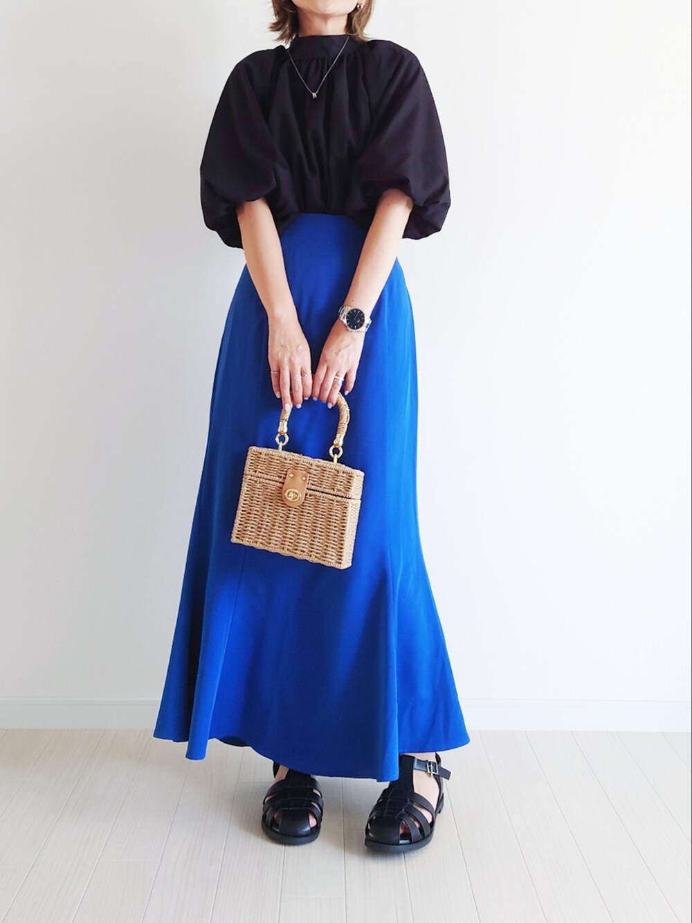ブラック系のシャツ/ブラウス、ブルー系のスカート、ブラウン系のかごバッグを着用したレディースの夏コーディネートの3枚目の写真