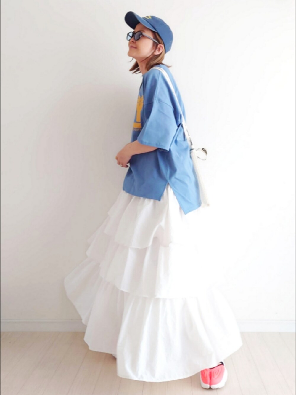 ブルー系のTシャツ/カットソー、ホワイト系のスカート、その他のスニーカーを着用したレディースの春コーディネートの3枚目の写真