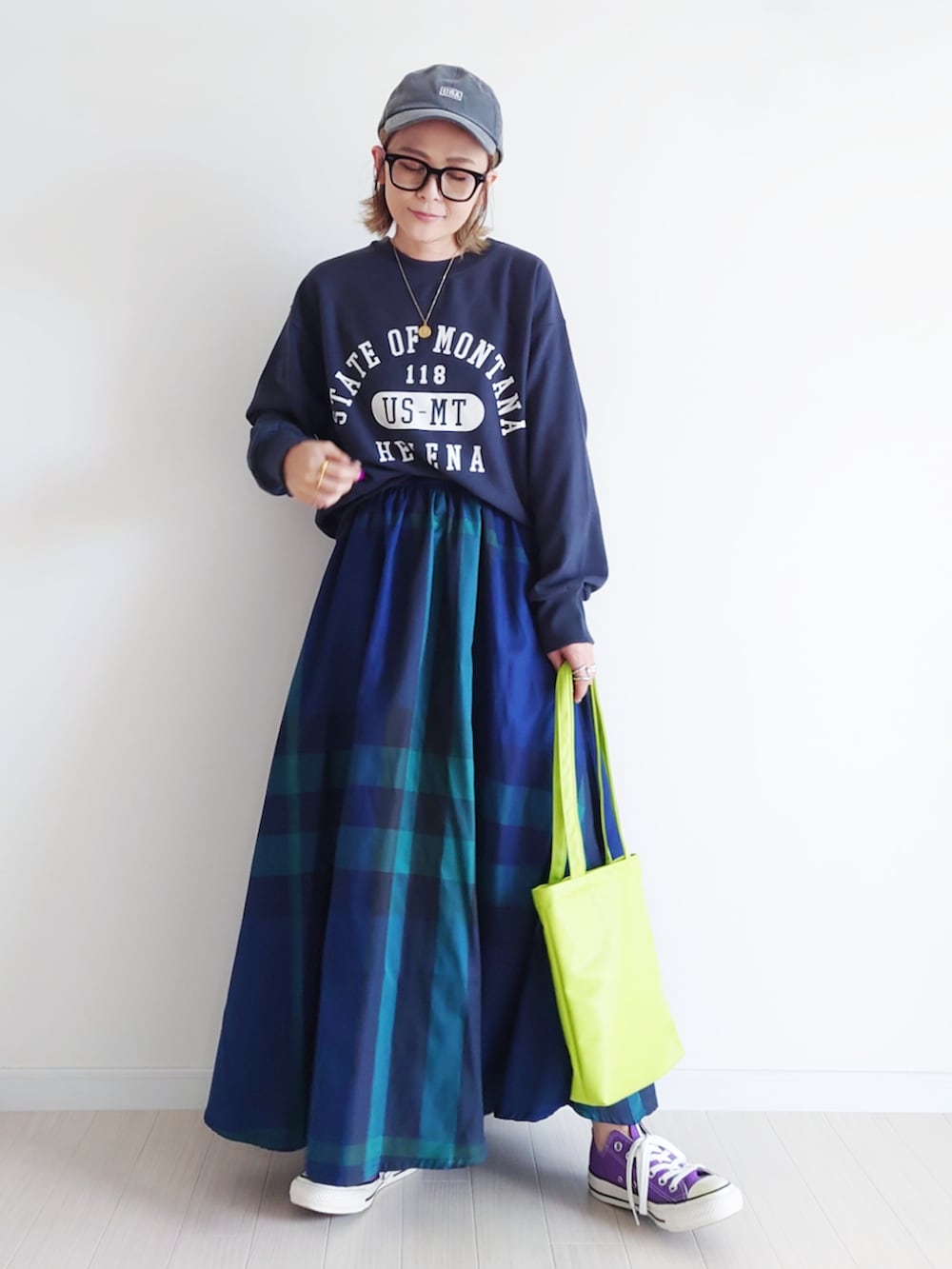 ブラック系のスウェット、ブルー系のスカート、パープル系のスニーカーを着用したレディースの秋コーディネートの2枚目の写真