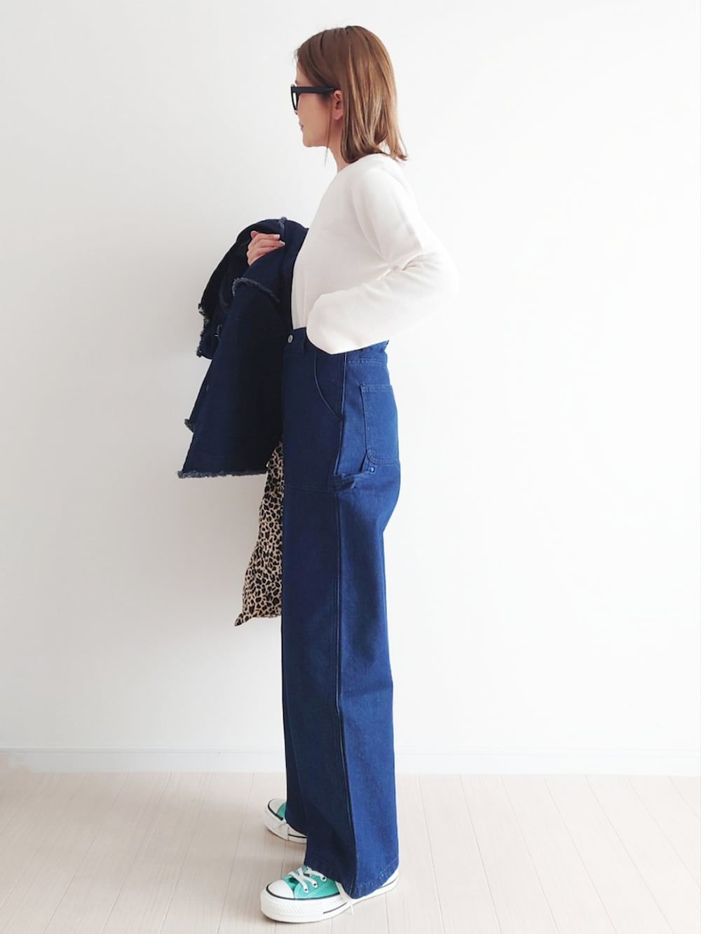 ブルー系のデニムジャケット、ホワイト系のニット/セーター、グリーン系のスニーカーを着用したレディースの春コーディネートの4枚目の写真