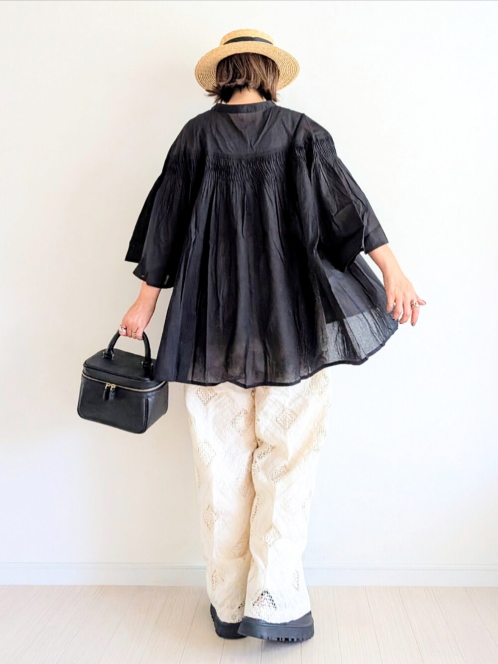 ブラック系のハンドバッグ、ブラック系のサンダル、ブラック系のシャツ/ブラウスを着用したレディースの夏コーディネートの4枚目の写真