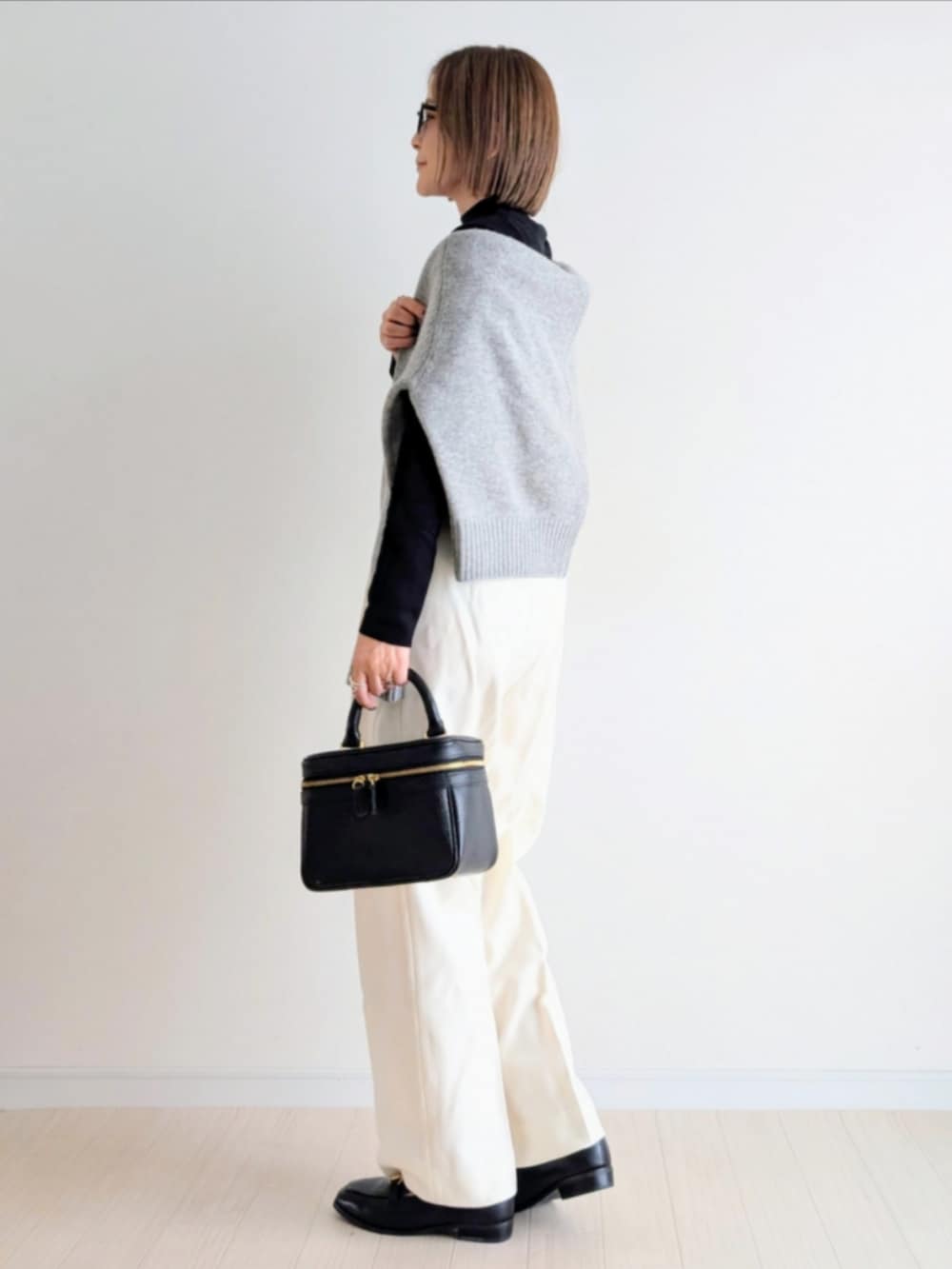 ブラック系のハンドバッグ、ブラック系のニット/セーター、グレー系のニット/セーターを着用したレディースの秋コーディネートの5枚目の写真