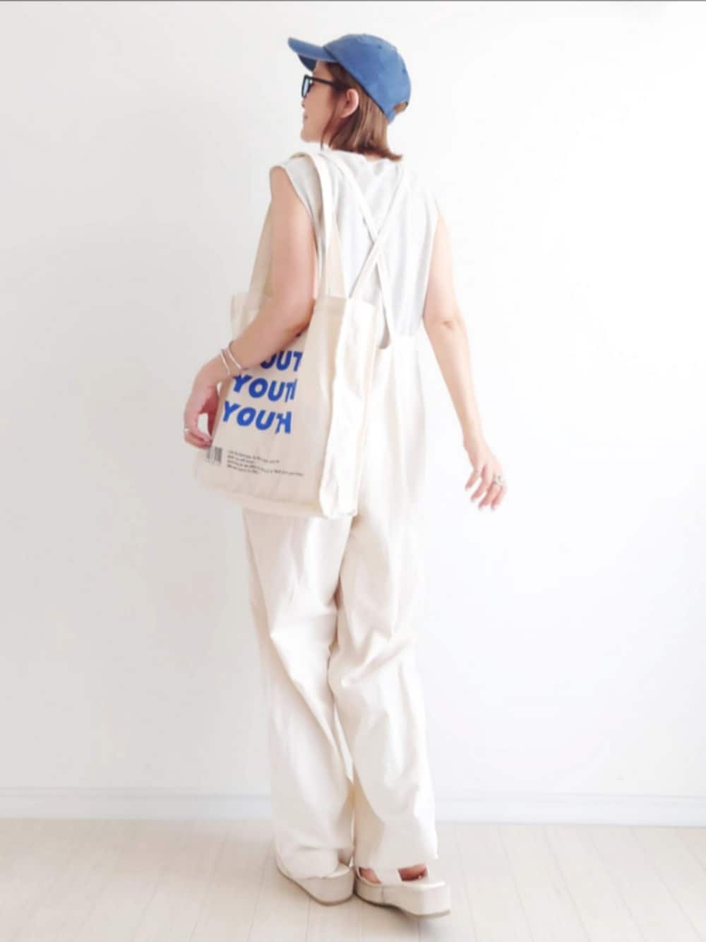 ホワイト系のサロペット/オーバーオール、ホワイト系のTシャツ/カットソー、ホワイト系のトートバッグを着用したレディースの夏コーディネートの4枚目の写真
