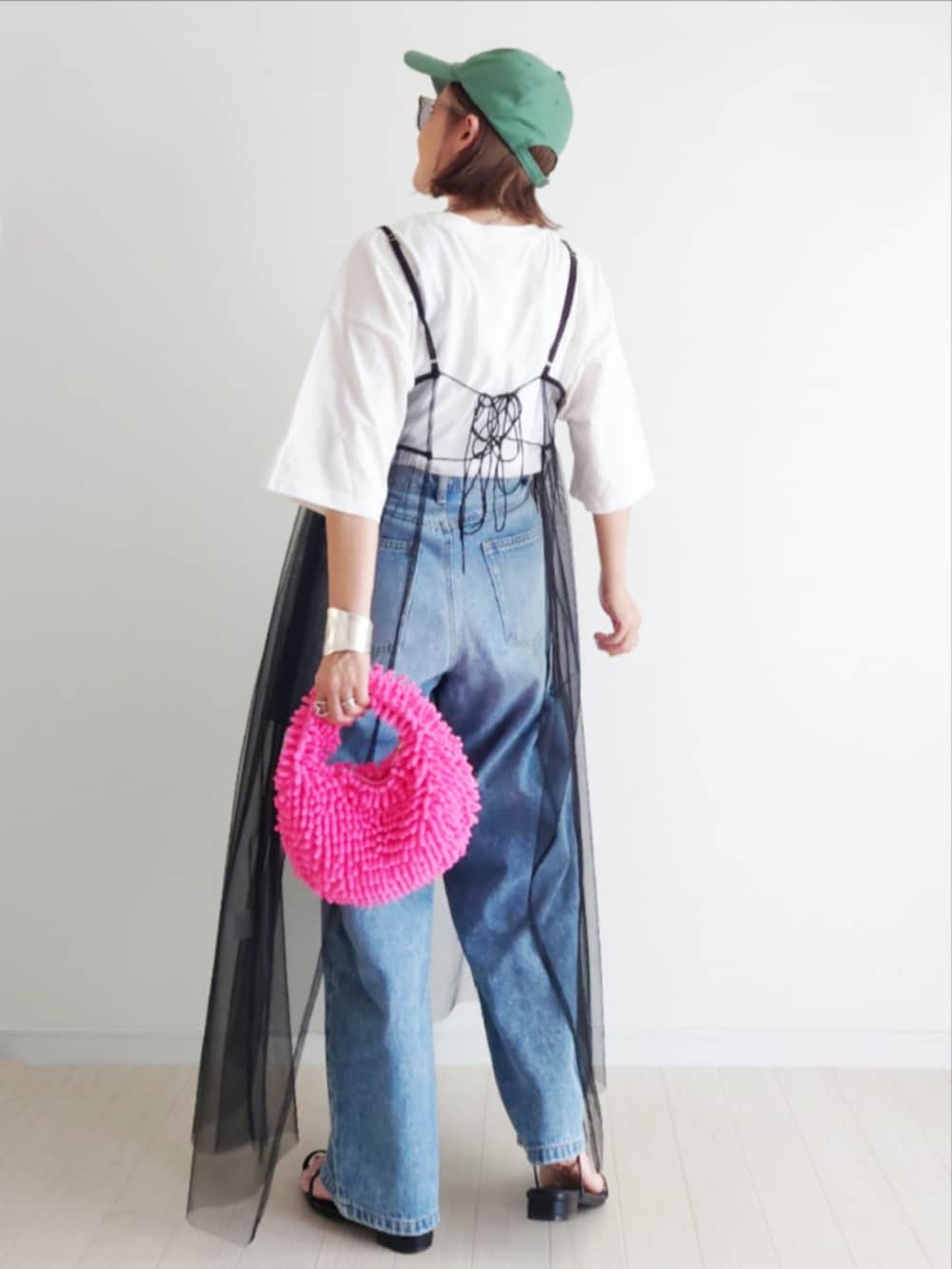 ブラック系のワンピース、ピンク系のトートバッグ、ブルー系のデニムパンツを着用したレディースの夏コーディネートの4枚目の写真