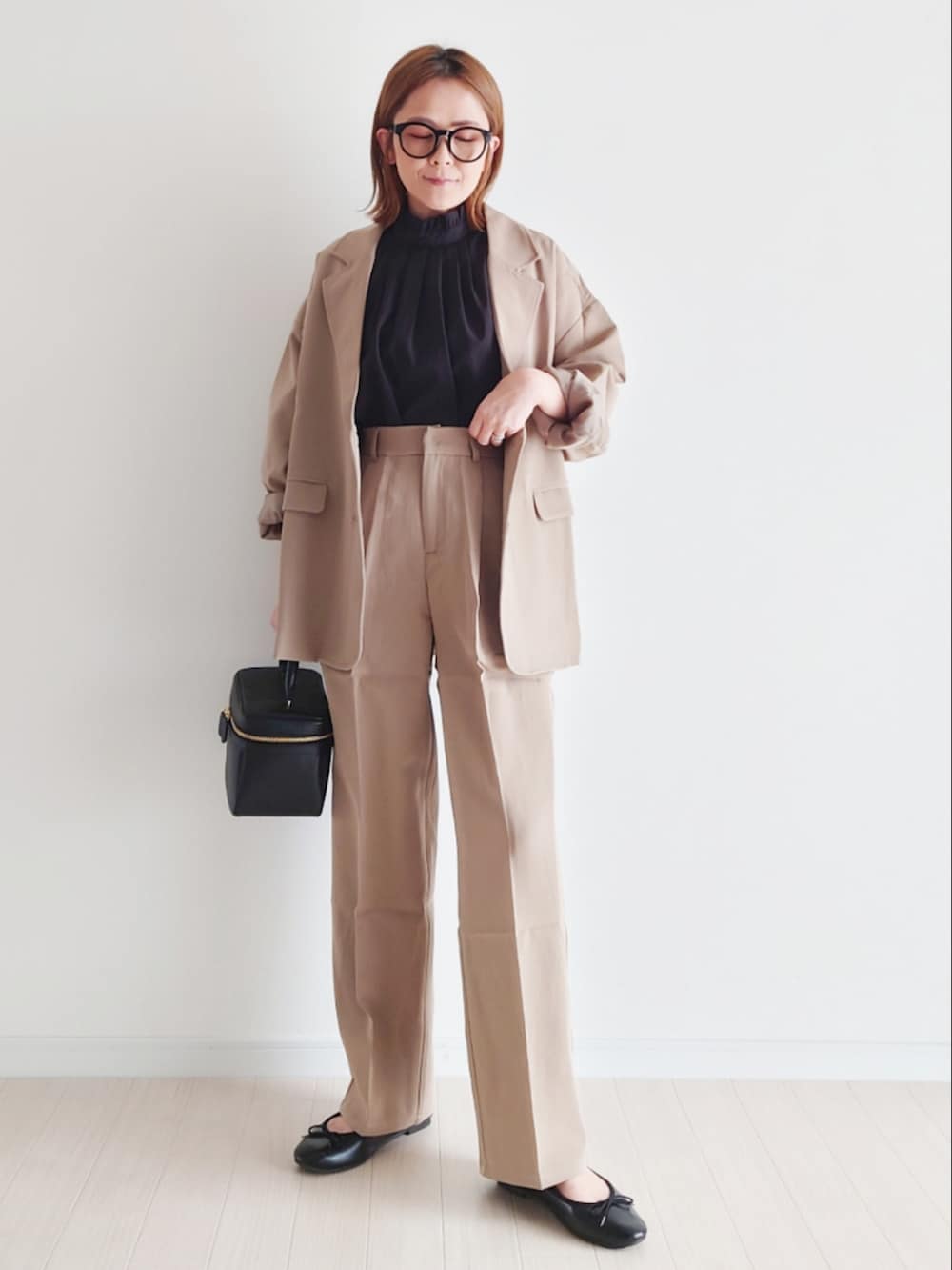 ベージュ系のセットアップ、ブラック系のシャツ/ブラウス、ブラック系のハンドバッグを着用したレディースの冬コーディネートの4枚目の写真