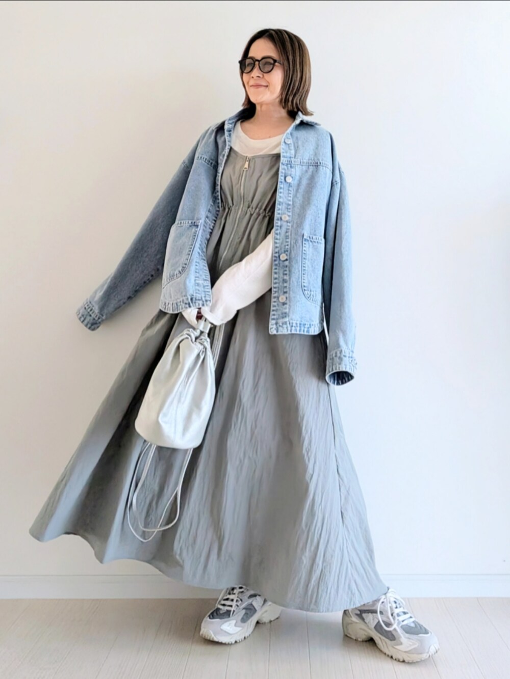 グレー系のワンピース、ホワイト系のTシャツ/カットソー、ブルー系のデニムジャケットを着用したレディースの春コーディネートの4枚目の写真