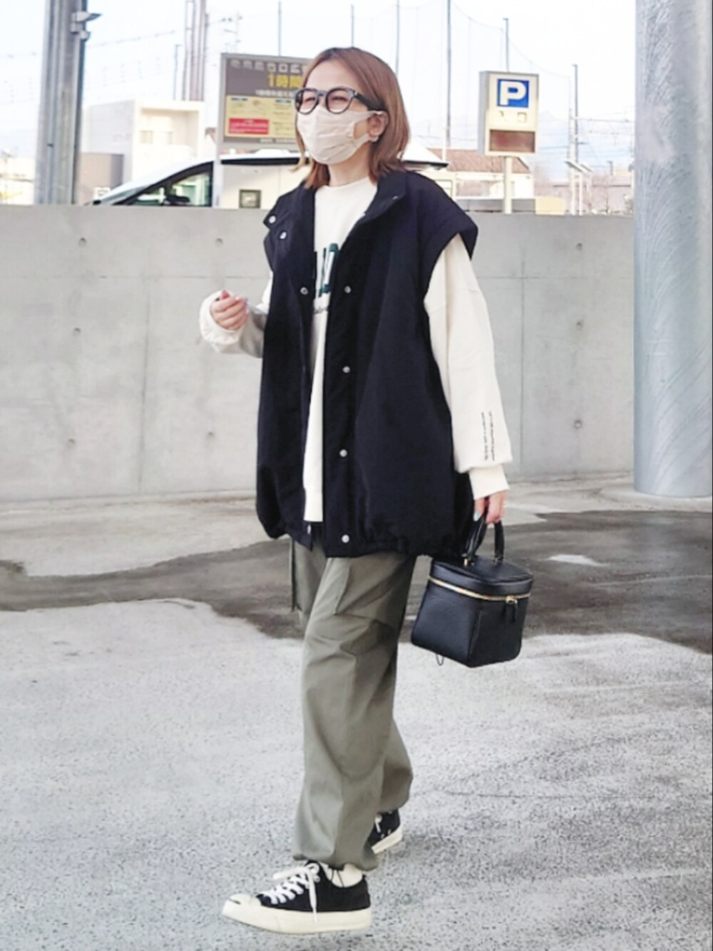 ブラック系のダウンジャケット/コート、ベージュ系のスウェット、グリーン系のカーゴパンツを着用したレディースの冬コーディネートの3枚目の写真