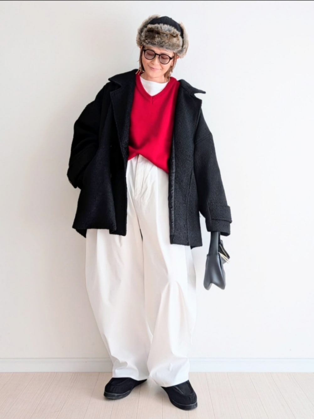 ブラック系のピーコート、レッド系のニット/セーターを着用したレディースの冬コーディネートの2枚目の写真