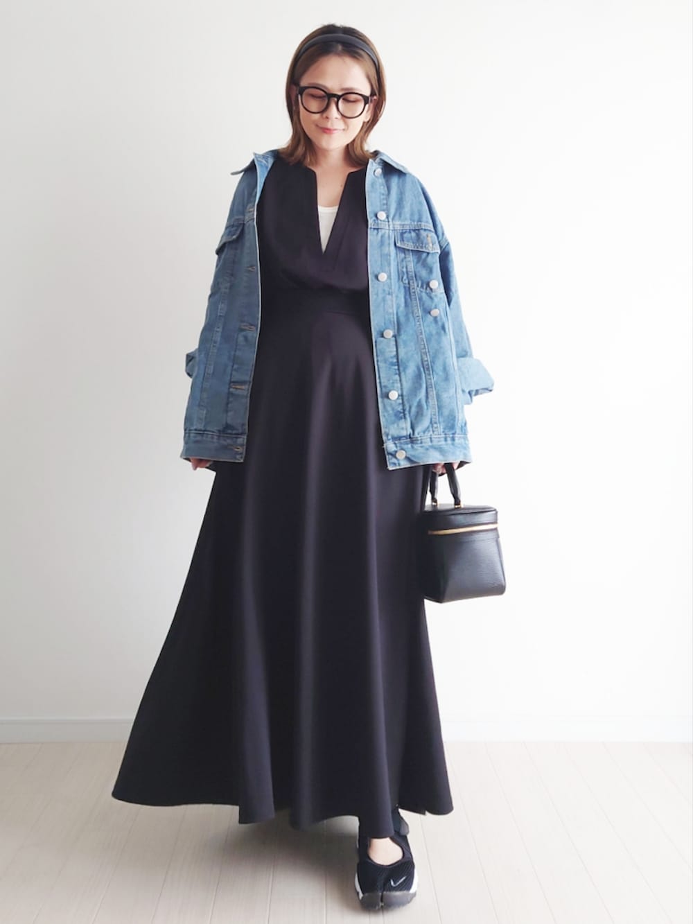 ブラック系のベスト、ブラック系のスカート、ブルー系のデニムジャケットを着用したレディースの春コーディネートの2枚目の写真