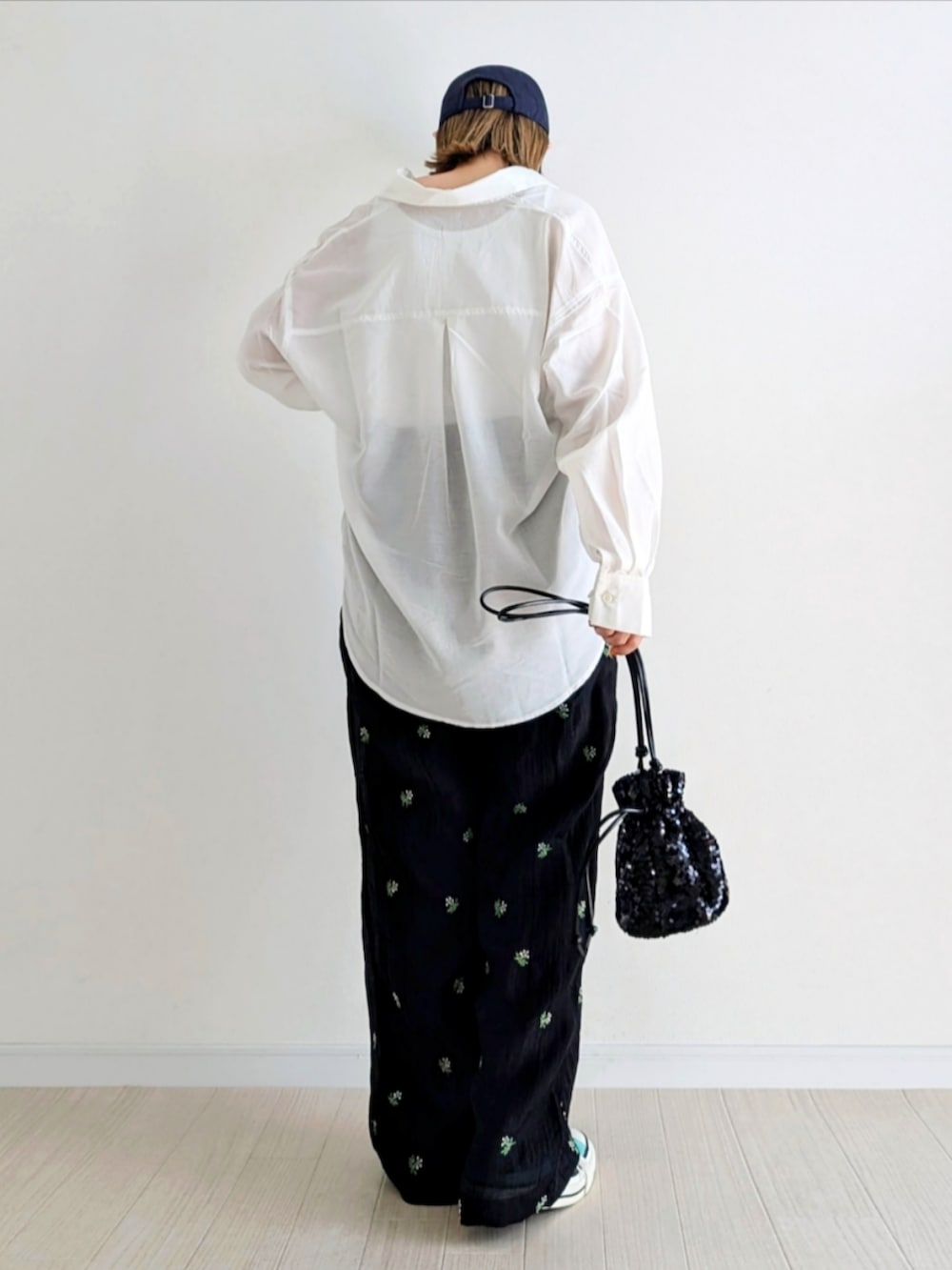 ブラック系のスラックス、ブラック系のショルダーバッグ、グリーン系のスニーカーを着用したレディースの春コーディネートの3枚目の写真