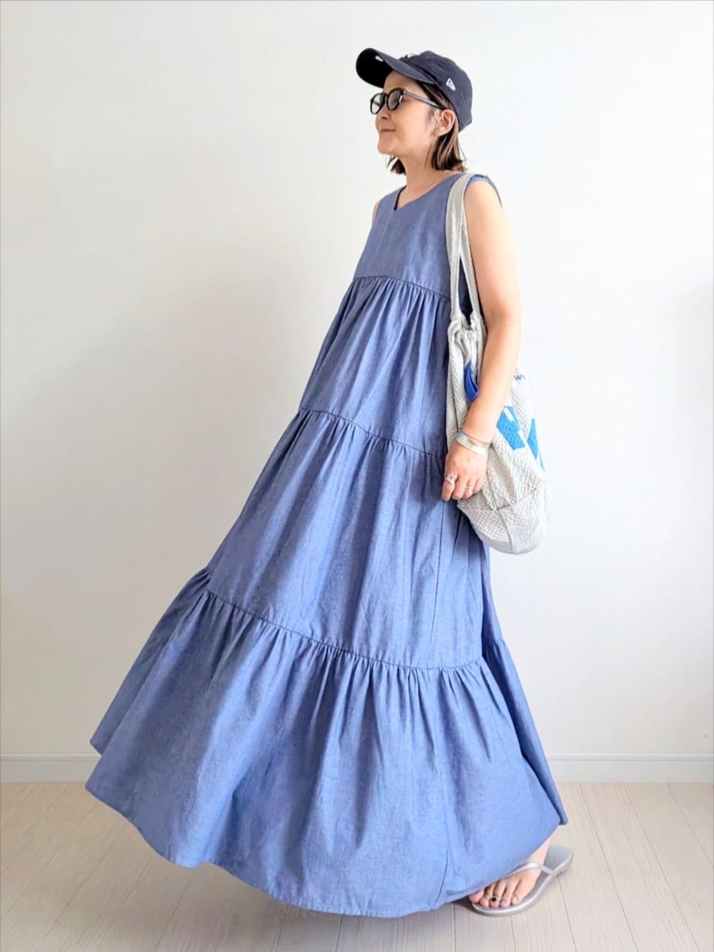ブルー系のワンピース、グレー系のトートバッグ、シルバー系のサンダルを着用したレディースの夏コーディネートの2枚目の写真