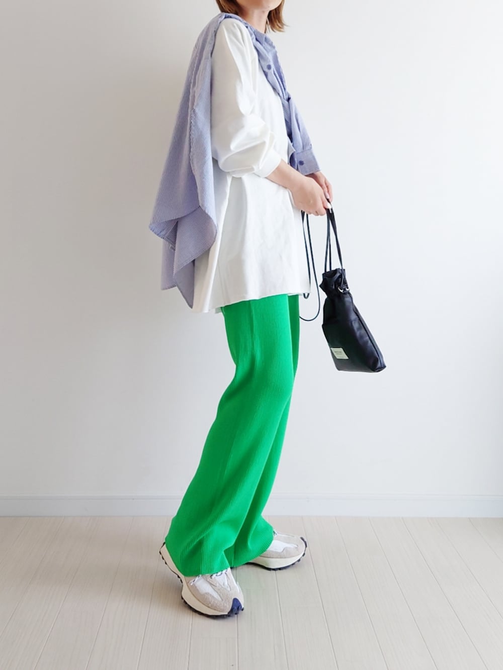 グリーン系のその他パンツ、ホワイト系のスニーカー、ブラック系のショルダーバッグを着用したレディースの春コーディネートの2枚目の写真