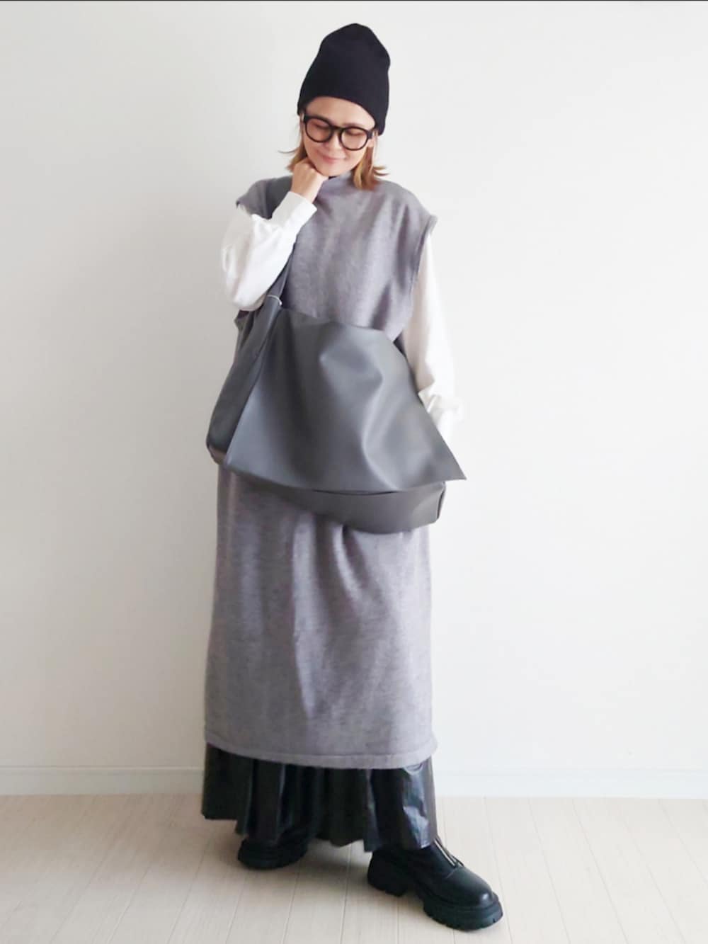 グレー系のワンピース、グレー系のショルダーバッグ、ブラック系のブーツを着用したレディースの秋コーディネートの3枚目の写真