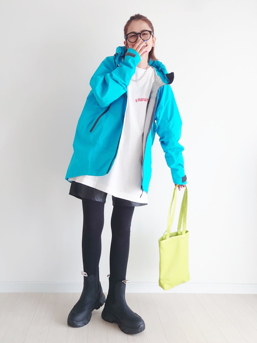 ブルー系のマウンテンパーカー、ホワイト系のTシャツ/カットソー、ブラック系のブーツを着用したレディースの秋コーディネートの2枚目の写真