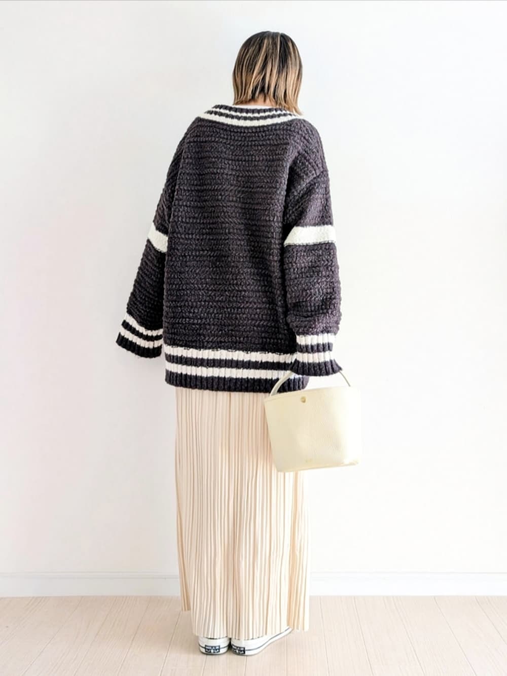 ホワイト系のスカート、グレー系のニット/セーター、その他のシューズを着用したレディースの冬コーディネートの4枚目の写真