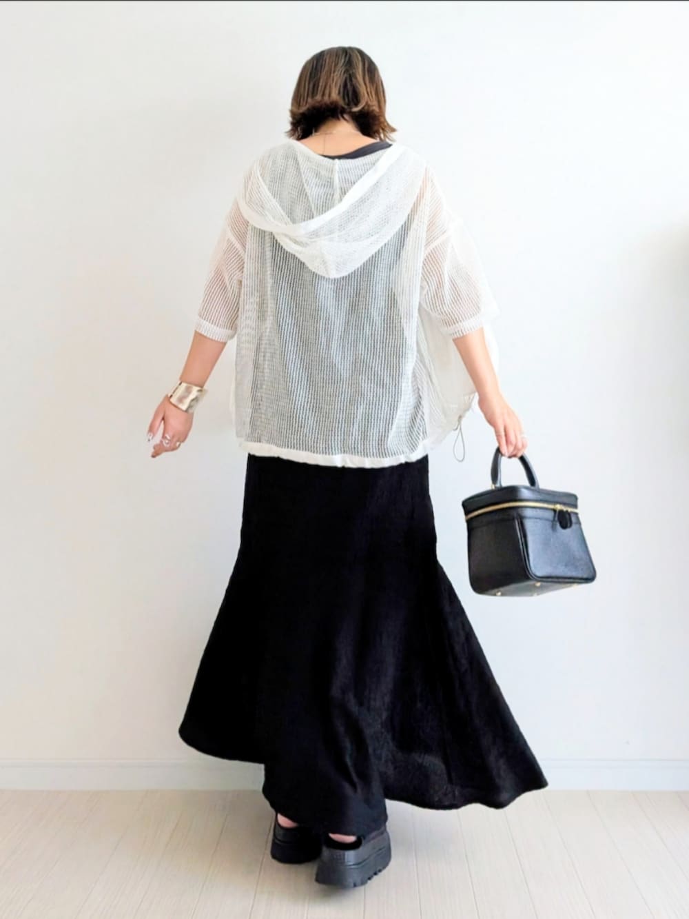 ブラック系のサンダル、ブラック系のワンピース、ホワイト系のパーカーを着用したレディースの夏コーディネートの3枚目の写真