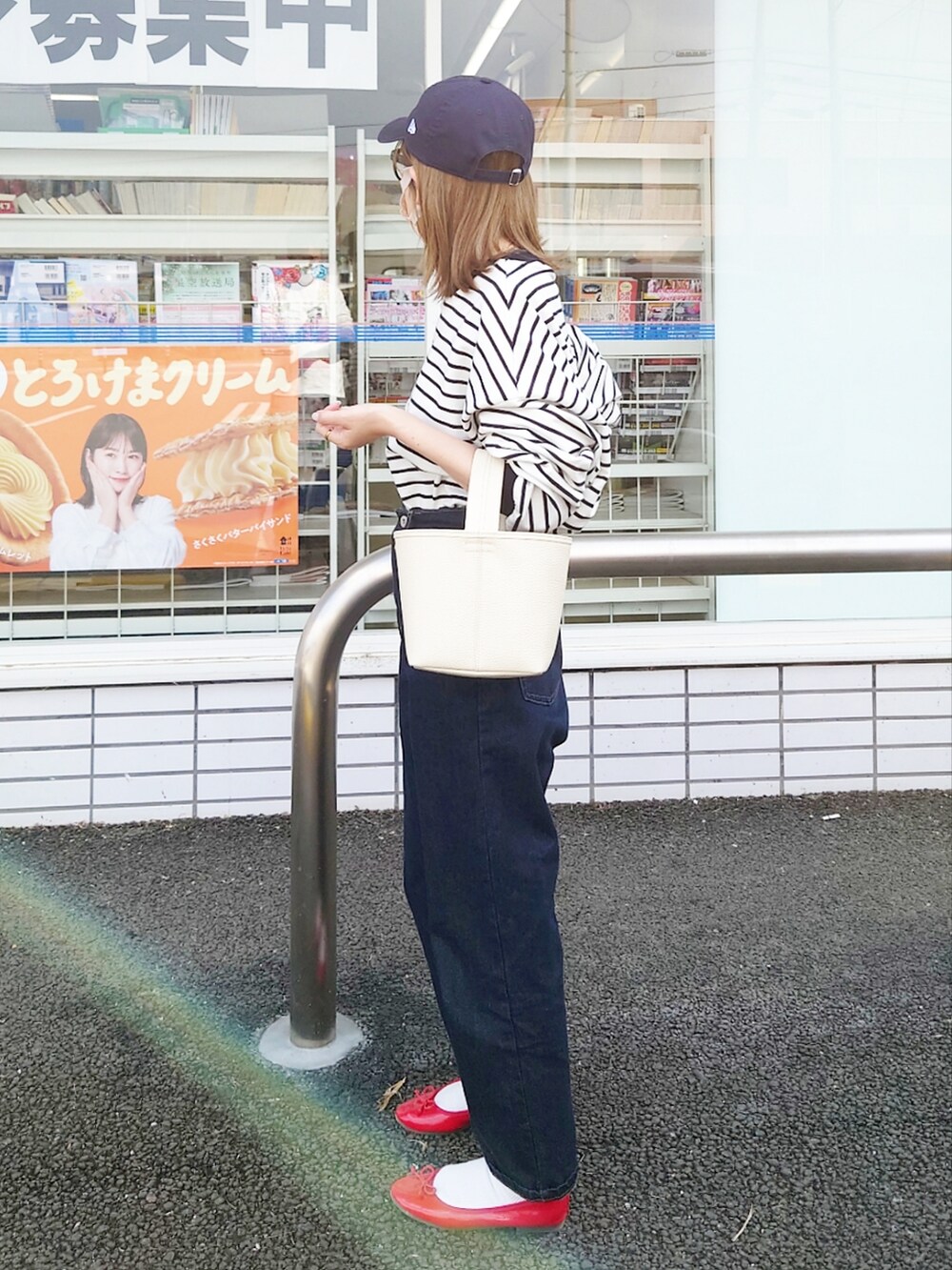 ブラック系のTシャツ/カットソー、ブルー系のデニムパンツ、ホワイト系のハンドバッグを着用したレディースの春コーディネートの2枚目の写真